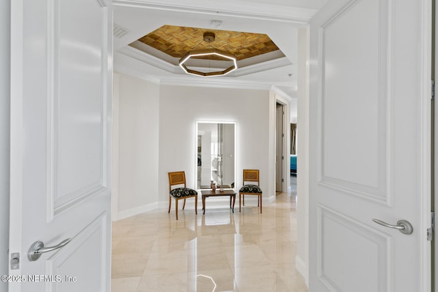 corridor with a raised ceiling, crown molding, and baseboards