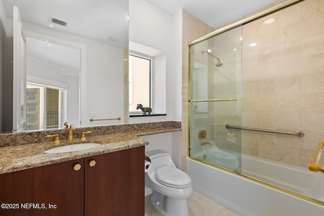 full bath with toilet, enclosed tub / shower combo, vanity, and plenty of natural light