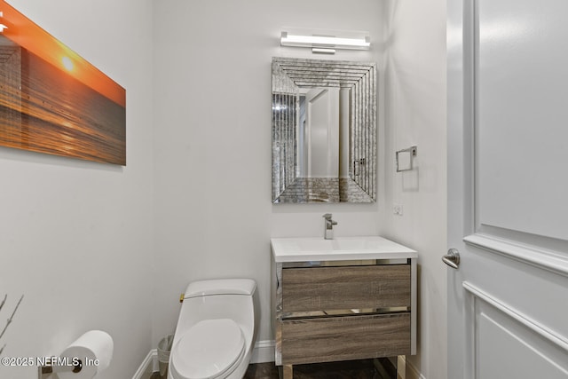 bathroom with vanity, baseboards, and toilet