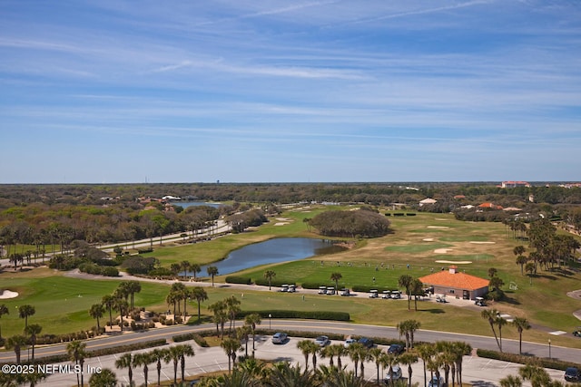 aerial view of a golf course, a large body of water, and a tree filled landscape