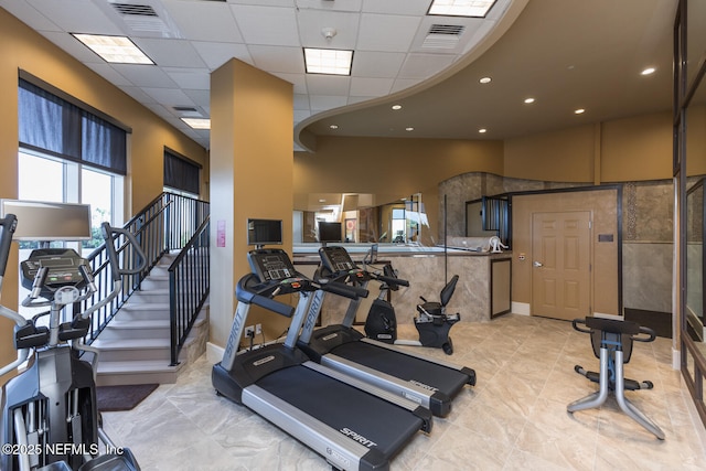 workout area featuring a paneled ceiling, recessed lighting, and baseboards