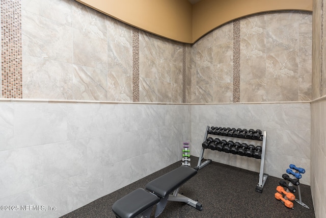 workout area featuring tile walls