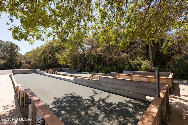 view of home's community featuring a game area and view of wooded area