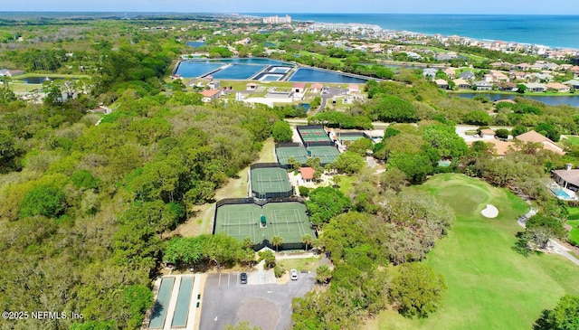 aerial view of property's location with a large body of water, a golf course, and nearby suburban area