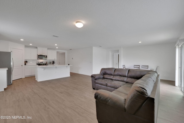 2304 Shady Breeze Ln, Green Cove Springs, FL 32043 - living area with light wood-type flooring, recessed lighting, and a textured ceiling
