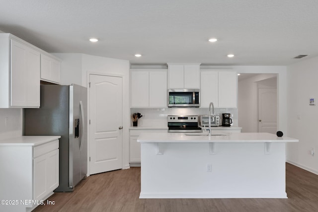 2304 Shady Breeze Ln, Green Cove Springs, FL 32043 - kitchen with appliances with stainless steel finishes, wood finished floors, white cabinets, and recessed lighting