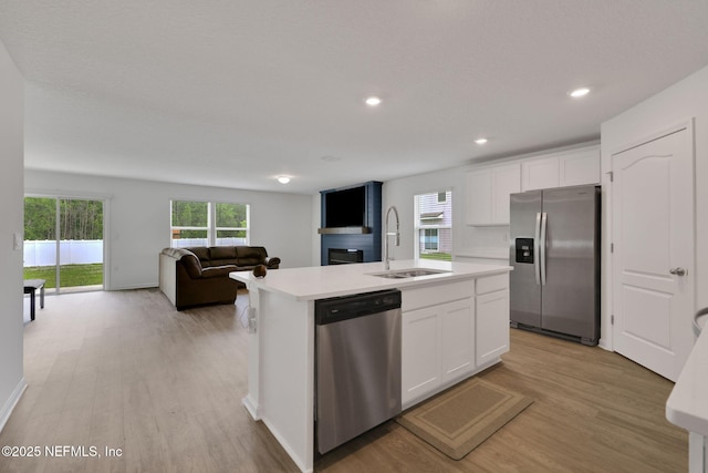 2304 Shady Breeze Ln, Green Cove Springs, FL 32043 - kitchen with appliances with stainless steel finishes, a sink, light wood-style flooring, white cabinets, and light countertops