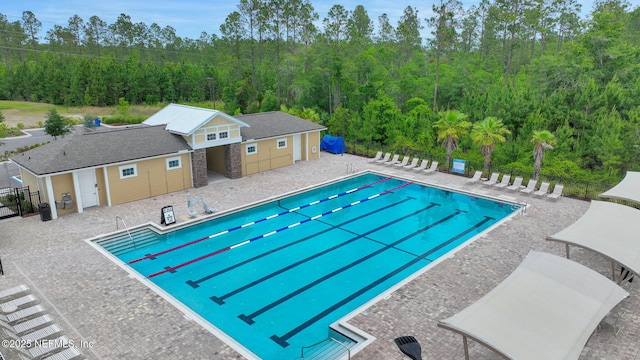 2304 Shady Breeze Ln, Green Cove Springs, FL 32043 - community pool featuring a patio area, fence, an outbuilding, and a forest view