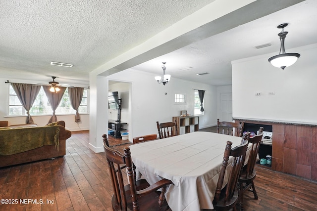 5388 Woodcrest Rd, Jacksonville, FL 32205 - dining space with dark wood-type flooring, a textured ceiling, a ceiling fan, a chandelier, and baseboards