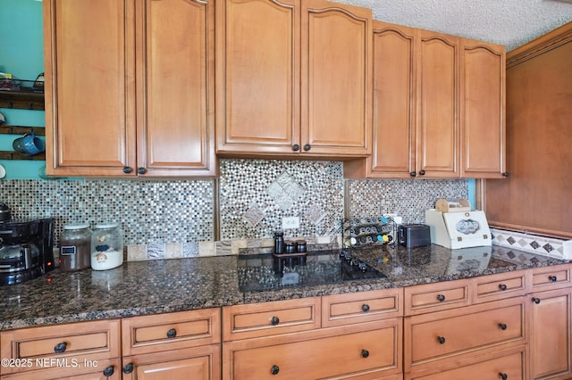 5388 Woodcrest Rd, Jacksonville, FL 32205 - kitchen featuring black electric stovetop, decorative backsplash, and dark stone countertops