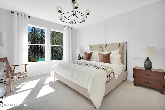 bedroom featuring light colored carpet and a chandelier