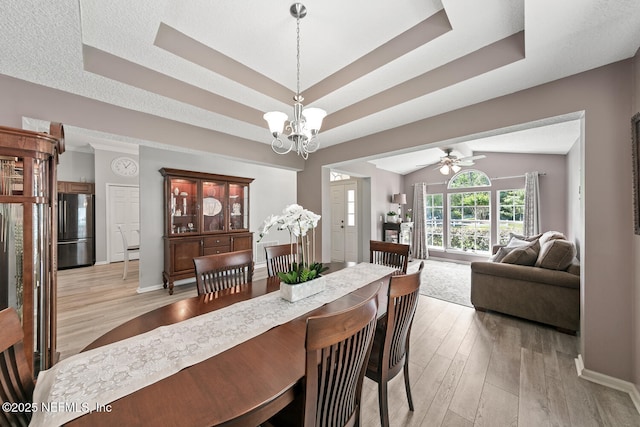 116 Greenfield Dr, Saint Johns, FL 32259 - dining space with a tray ceiling, light wood-type flooring, a chandelier, baseboards, and ceiling fan