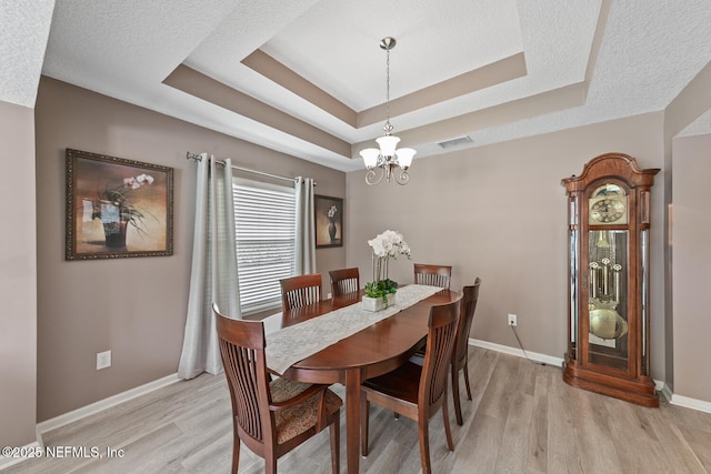 116 Greenfield Dr, Saint Johns, FL 32259 - dining area featuring a chandelier, light wood-type flooring, baseboards, and a tray ceiling