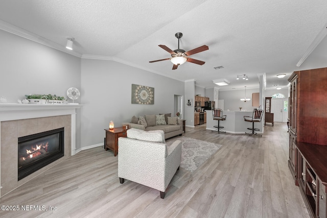 116 Greenfield Dr, Saint Johns, FL 32259 - living room with light wood-style floors, ceiling fan, a tile fireplace, crown molding, and lofted ceiling