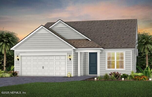 view of front of house featuring an attached garage, driveway, a shingled roof, and a front lawn