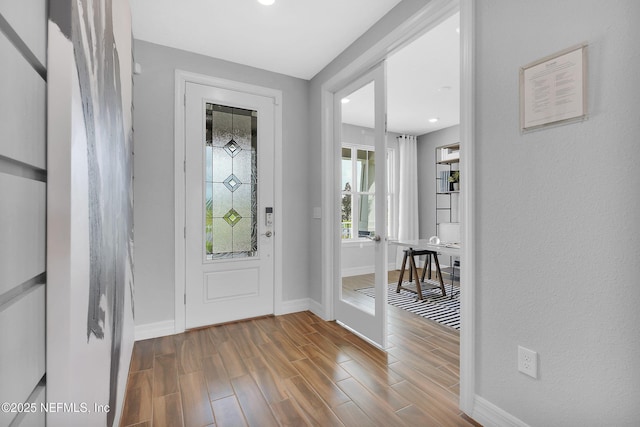 entryway featuring baseboards, wood finished floors, and recessed lighting