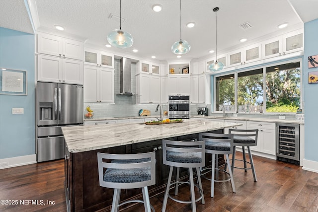 182 N Ridge Dr, Fleming Island, FL 32003 - kitchen featuring appliances with stainless steel finishes, wine cooler, wall chimney exhaust hood, decorative backsplash, and recessed lighting