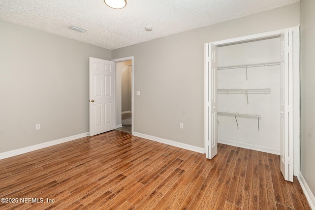 133 Sterling Hill Dr, Jacksonville, FL 32225 - unfurnished bedroom featuring wood finished floors, a closet, a textured ceiling, baseboards, and a spacious closet