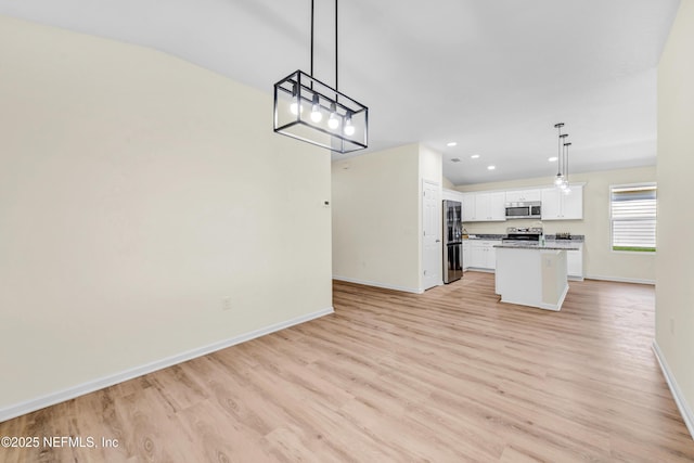 1902 Gillis St, Palatka, FL 32177 - kitchen featuring appliances with stainless steel finishes, open floor plan, baseboards, light wood-type flooring, and white cabinets