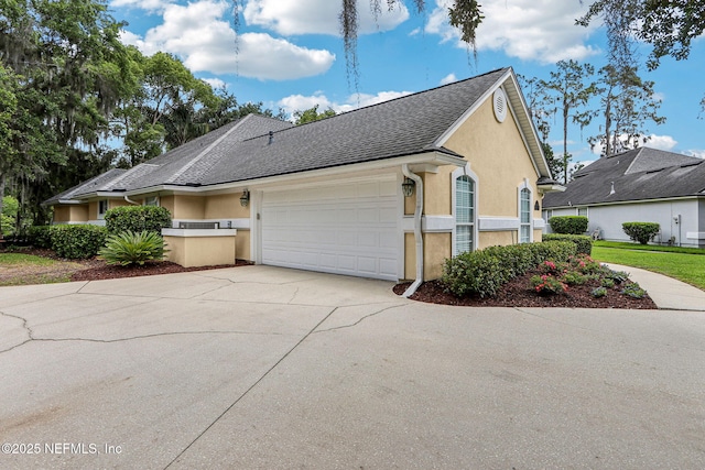 1700 Eagle Watch Dr, Fleming Island, FL 32003 - view of property exterior featuring stucco siding, a garage, driveway, and roof with shingles