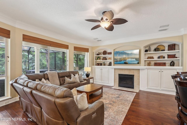 1700 Eagle Watch Dr, Fleming Island, FL 32003 - living area featuring a textured ceiling, a ceiling fan, ornamental molding, built in features, and dark wood-style flooring