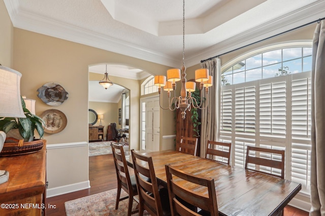 1700 Eagle Watch Dr, Fleming Island, FL 32003 - dining space with ornamental molding, a chandelier, arched walkways, wood finished floors, and a tray ceiling