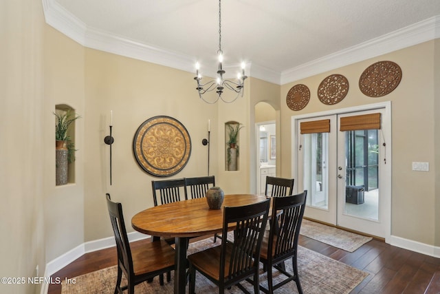 1700 Eagle Watch Dr, Fleming Island, FL 32003 - dining area featuring french doors, crown molding, arched walkways, a chandelier, and dark wood-style flooring