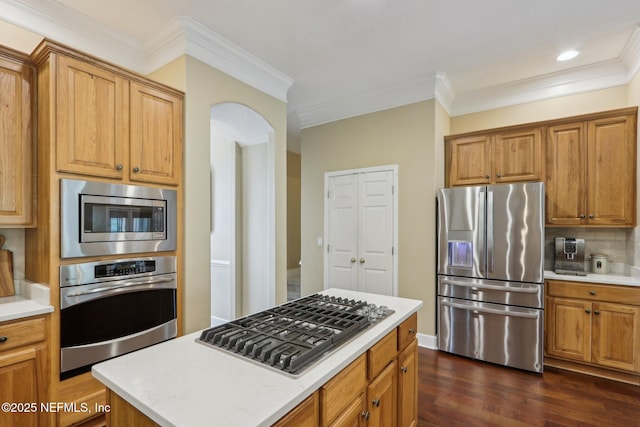 1700 Eagle Watch Dr, Fleming Island, FL 32003 - kitchen with stainless steel appliances, ornamental molding, backsplash, light countertops, and dark wood-style flooring