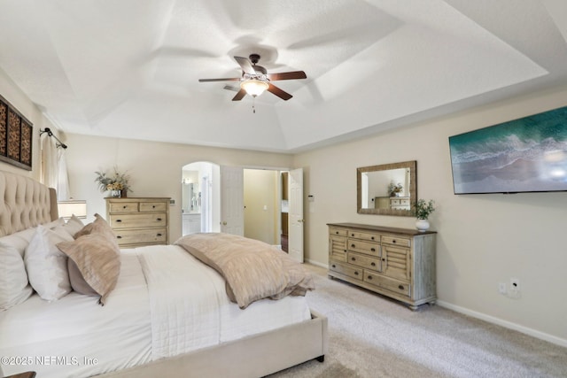 1700 Eagle Watch Dr, Fleming Island, FL 32003 - bedroom with arched walkways, a raised ceiling, light carpet, connected bathroom, and baseboards