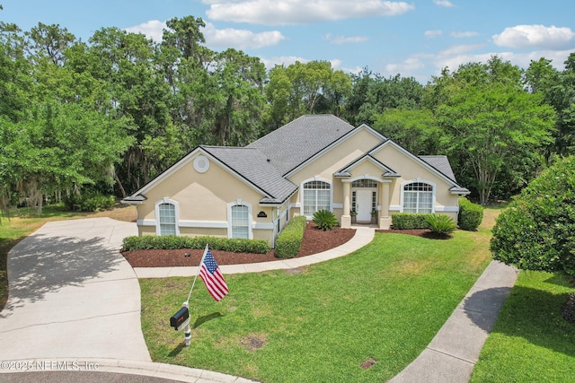 1700 Eagle Watch Dr, Fleming Island, FL 32003 - ranch-style house with stucco siding, concrete driveway, a front yard, and view of scattered trees