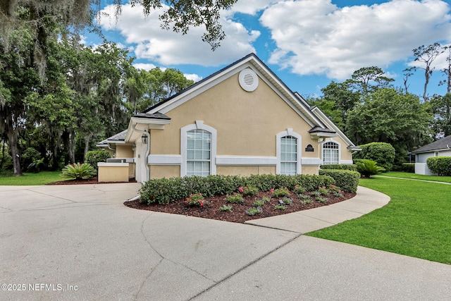 1700 Eagle Watch Dr, Fleming Island, FL 32003 - view of front facade featuring stucco siding, a front yard, and driveway