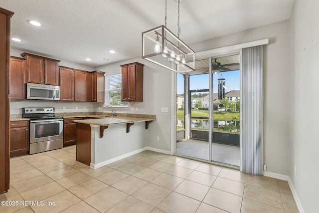 168 Nelson Ln, Saint Johns, FL 32259 - kitchen with appliances with stainless steel finishes, a peninsula, a breakfast bar, recessed lighting, and pendant lighting