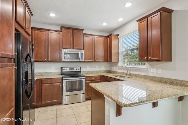168 Nelson Ln, Saint Johns, FL 32259 - kitchen featuring stainless steel appliances, a sink, a peninsula, light tile patterned flooring, and light stone counters