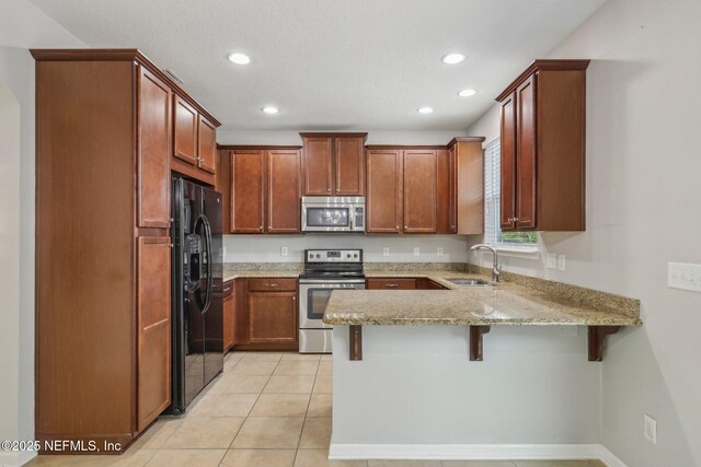 168 Nelson Ln, Saint Johns, FL 32259 - kitchen featuring stainless steel appliances, a sink, a peninsula, light stone countertops, and recessed lighting