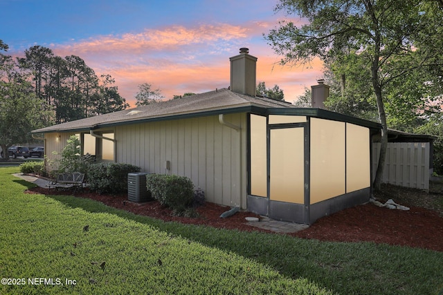 9250 Arbolita Way, Jacksonville, FL 32256 - property exterior at dusk with a chimney, a lawn, and cooling unit