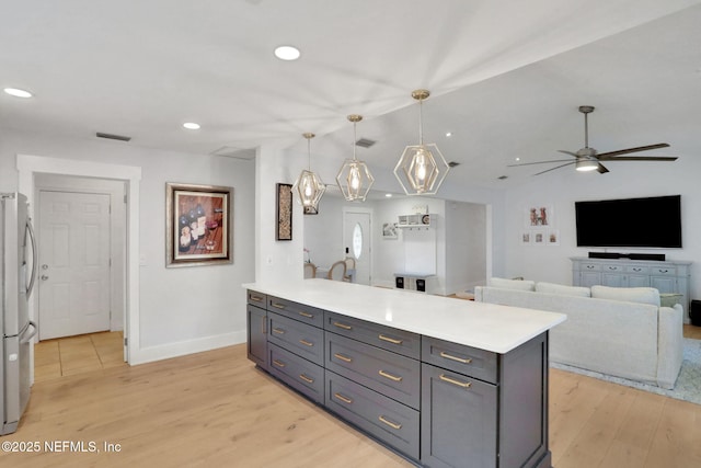 1257 12th St N, Jacksonville Beach, FL 32250 - kitchen featuring light wood finished floors, light countertops, freestanding refrigerator, a ceiling fan, and gray cabinetry