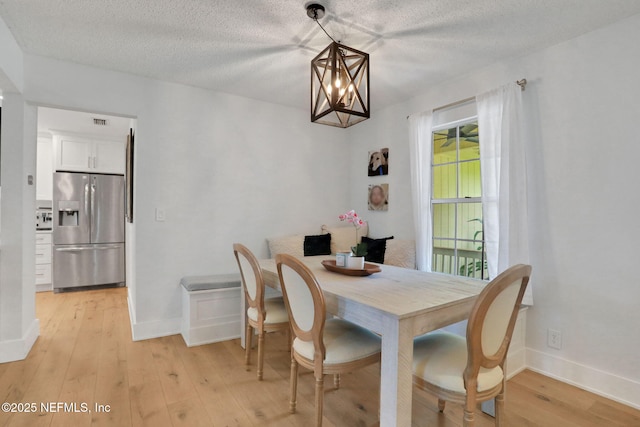 1257 12th St N, Jacksonville Beach, FL 32250 - dining space featuring light wood-style flooring, a textured ceiling, baseboards, and a chandelier