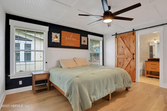 1257 12th St N, Jacksonville Beach, FL 32250 - bedroom with a barn door, light wood finished floors, a ceiling fan, and ensuite bathroom