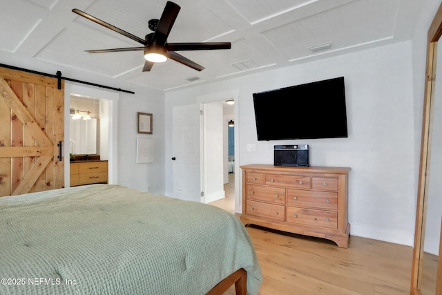 1257 12th St N, Jacksonville Beach, FL 32250 - bedroom with light wood finished floors, a barn door, connected bathroom, baseboards, and a ceiling fan