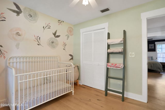 1257 12th St N, Jacksonville Beach, FL 32250 - bedroom with wood finished floors, a closet, baseboards, a crib, and a ceiling fan