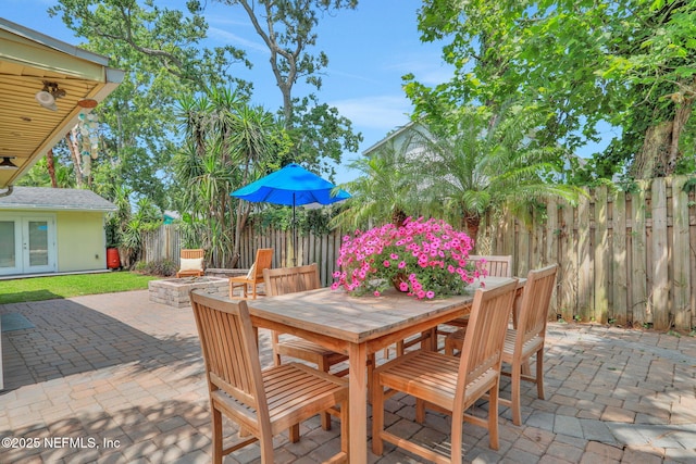 1257 12th St N, Jacksonville Beach, FL 32250 - view of patio with french doors, outdoor dining area, a fenced backyard, and an outdoor fire pit