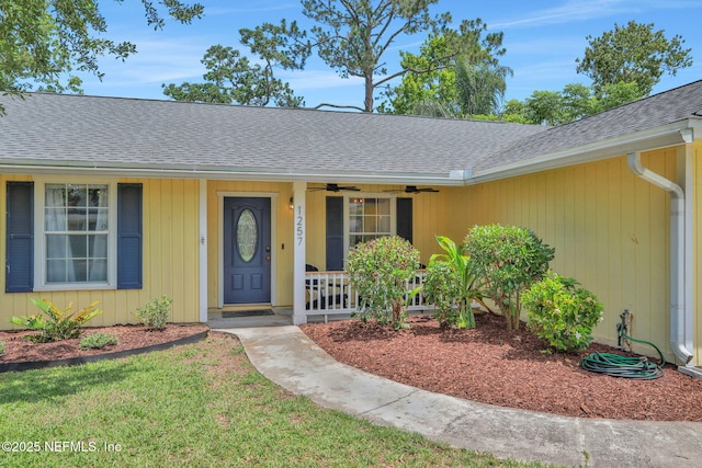 1257 12th St N, Jacksonville Beach, FL 32250 - property entrance with a shingled roof, a ceiling fan, a porch, and a lawn