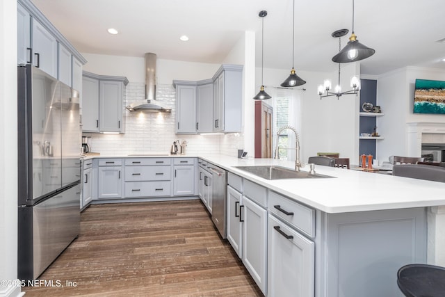 1800 Rear Admiral Ln, Saint Johns, FL 32259 - kitchen featuring appliances with stainless steel finishes, wall chimney range hood, a sink, gray cabinets, and a peninsula