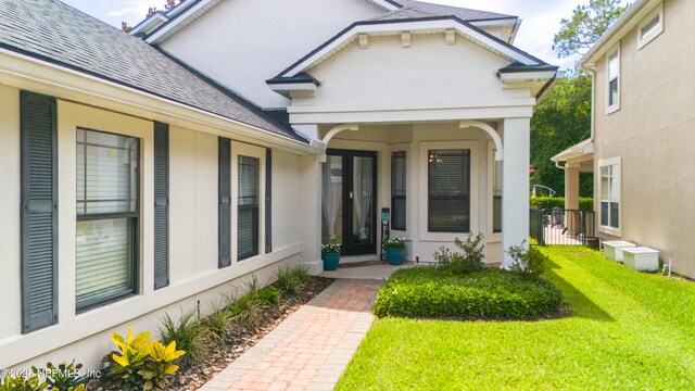 1800 Rear Admiral Ln, Saint Johns, FL 32259 - entrance to property featuring roof with shingles, a yard, and stucco siding