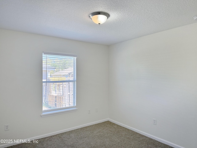 unfurnished room with carpet, a textured ceiling, and baseboards