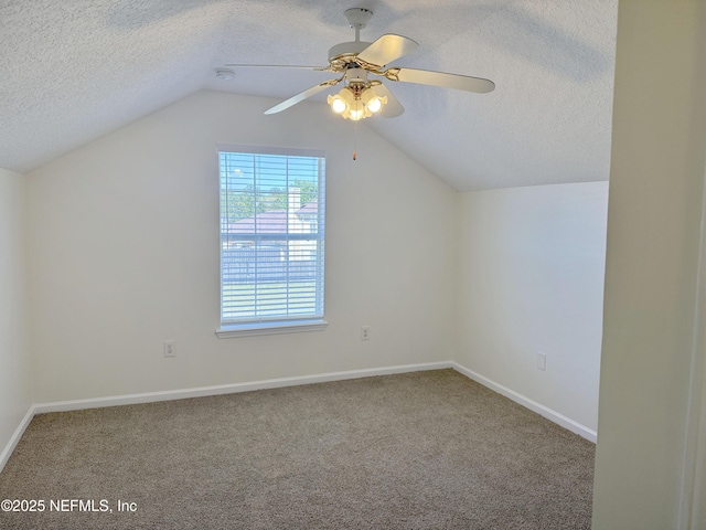 bonus room with a textured ceiling, vaulted ceiling, carpet, a ceiling fan, and baseboards