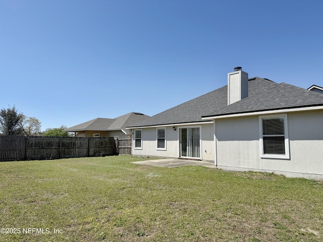 back of property featuring a patio, a chimney, and a shingled roof