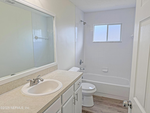 full bath featuring wood finished floors, toilet, vanity, and bathtub / shower combination