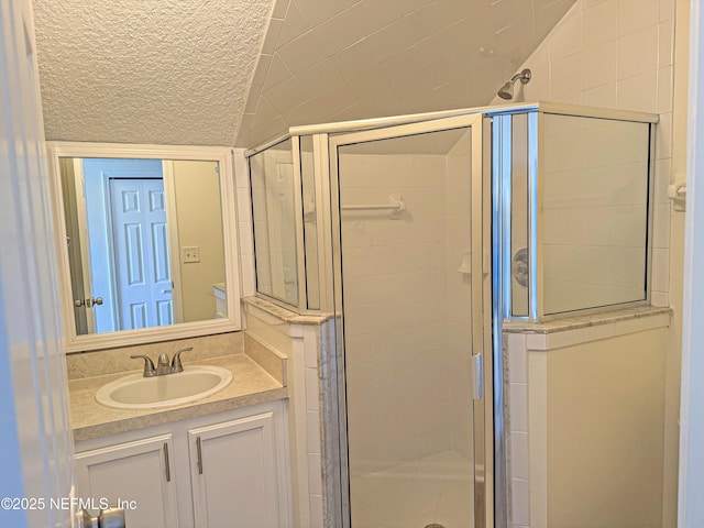 bathroom with a stall shower, lofted ceiling, and vanity