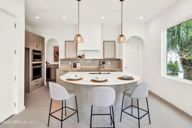 114 12th Ave S Unit 102, Jacksonville Beach, FL 32250 - kitchen with light countertops, decorative backsplash, stainless steel double oven, a kitchen bar, and recessed lighting